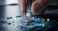 Hand holding CPU chip with tweezers, installing it onto a glowing circuit board with other components Royalty Free Stock Photo