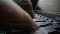 Close-Up of a Hand Typing on a Laptop Keyboard Surrounded by Code and Programming Elements in a Modern Software Royalty Free Stock Photo