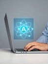 Hand typing on laptop with futuristic atom graphic. Person interacting with modern laptop featuring AI Royalty Free Stock Photo