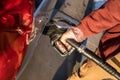 Close up on hand of unknown caucasian man hold black gas pump nozzle pouring gasoline into the fuel tank refueling petroleum to Royalty Free Stock Photo