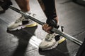 Close up on hand of unknown caucasian man holding barbell weight grip at gym lifting weights in training wearing dark black gloves Royalty Free Stock Photo