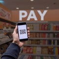 Close-up of hand using phone to scan QR code in store. generative ai
