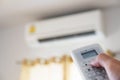 Close-up hand using remote control of air condition, selective focus Royalty Free Stock Photo