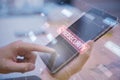 Close up of hand using tablet with glowing hacking hologram and binary code lines on blurry backdrop. Cybersecurity, firewall,