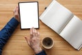 Close up hand using tablet and note book white screen on workspace table, coffee break. Royalty Free Stock Photo