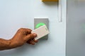 Close-up of a hand using a white keycard to open an electronic door lock with an access control system