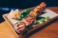 Close-up Hand Waiter holding Set Delicious fresh Sushi slate plate Sushi Rolls Warm Ebi Sake Unagi, Japanese raw fish in