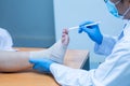 Close-up hand wear medical gloves doctor examines the leg of the womanÃ¢â¬â¢s heel for heel spurs, pain in the foot, plantar