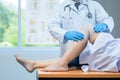 Close-up hand wear medical gloves doctor examining head of patient with knee problems in clinic