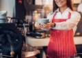 Close up hand of woman barista wear red apron holding hot coffee Royalty Free Stock Photo
