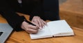 Close up hand of woman hand holding pen taking note and working with laptop at the table office Royalty Free Stock Photo