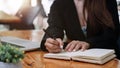 Close up hand of woman hand holding pen taking note and working with laptop at the table office Royalty Free Stock Photo