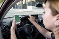 Hand of woman holding steering wheel and mobile phone driving car while texting distracted in risk Royalty Free Stock Photo