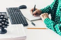 Close-up of hand woman makes notes and using a mouse and typing on keyboard on white table, business concept Royalty Free Stock Photo