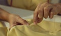 Close up hand woman tailor with needle stitching on button to shirt Royalty Free Stock Photo