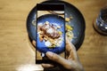 Close up of hand of a woman taking a photo of food with mobile phone. Sharing on social media Royalty Free Stock Photo