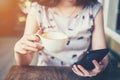 Close up of hand woman using phone in coffee shop with depth of Royalty Free Stock Photo