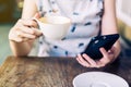 Close up hand woman using smartphone in coffee shop