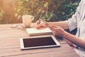 Close up hand woman writing notebook and holding phone in coffee Royalty Free Stock Photo