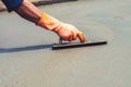 close up hand worker leveling concrete pavement for mix cement a Royalty Free Stock Photo