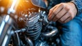 Close-Up of Hand Working on Motorcycle Engine Component with Sunlight Reflection Royalty Free Stock Photo