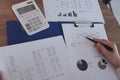 Close-up of hand working in office, studying using calculator and writing something with documents and chart on table Royalty Free Stock Photo