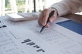 close-up of hand working in office, studying using calculator and writing something with documents and chart on table. Royalty Free Stock Photo