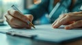 Close-up of a hand writing in a notebook with pen.