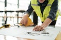 Close up of hand& x27;s architects working on blueprints in the office with drawing tools and a blueprint on his desk. Royalty Free Stock Photo