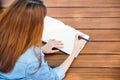 Close-up hand of young female student taking note in to diary book. Selective focus on hand holding a pen Royalty Free Stock Photo