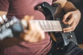 Close up hand of young man playing on a professional, black electric guitar, music instrument, entertainment, lifestyle Royalty Free Stock Photo