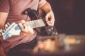 Close up hand of young man playing on a professional, black electric guitar, music instrument, entertainment, lifestyle Royalty Free Stock Photo