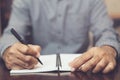 young man hand are sitting using pen writing Record Lecture note pad diary into the book Royalty Free Stock Photo