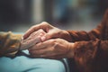 Close up of hand of young person holding hand of old person. Concept for wlderly care