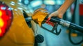 Close-up of the hand of a young woman with a red manicure filling her car with gasoline at a gas station. Gasoline or Royalty Free Stock Photo