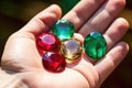 close-up of a handful of precious stones emeralds, rubies