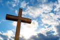 close-up of a handheld wooden cross against a bright sky
