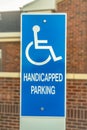 Close up of Handicapped Parking sign against blurred red brick wall of church Royalty Free Stock Photo