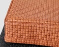 Close-up of handmade tan leather cushion with woven texture