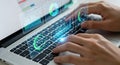 Hands typing on laptop keyboard with glowing digital interface overlay, showcasing data analysis and technology Royalty Free Stock Photo