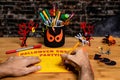 Close up of the hands of an adult male Doing crafts and Making a Party Sign for Halloween.  Several Halloween Craft decorations Royalty Free Stock Photo