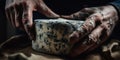 Close up hands an artisan cheese maker prepares a small-batch, cave-aged blue cheese, concept of Food fermentation