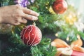 Close-up hands of asian women decorating red ball on christmas tree for prepare xmas party Royalty Free Stock Photo