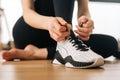 Close up hands of athletic female tying shoelaces on sports shoe preparing to workout. Close-up cropped shot of Royalty Free Stock Photo