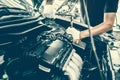 Close-up hands of auto mechanic are using the wrench to repair and maintenance auto engine