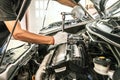 Close-up hands of auto mechanic are using the wrench to repair and maintenance auto engine