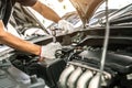 Close-up hands of auto mechanic are using the wrench to repair and maintenance auto engine i