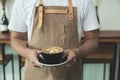 Close up hands of barista man holding cup of hot latte coffee in Royalty Free Stock Photo