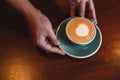 Close up of hands barista man serving coffee in coffee shop. male hands placing a cup of coffee on table. Royalty Free Stock Photo