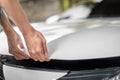Close up of hands being open the car hood or bonnet for maintenance checking engine before a trip or journey, Car check condition